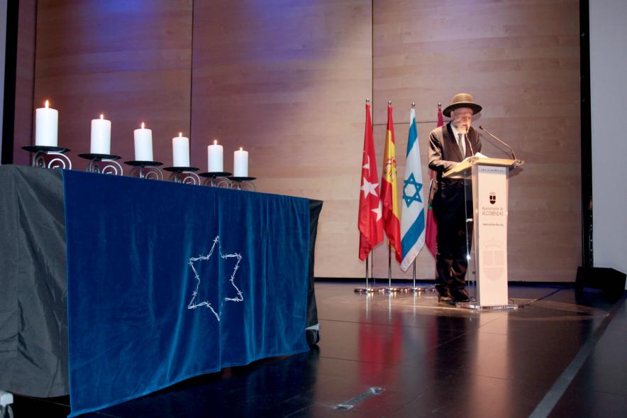  Acto Día de la Memoria del Holocausto 2022 - Imagen lateral de la mesa con las velas  encendidas y el Rabino Moses Bendehan.