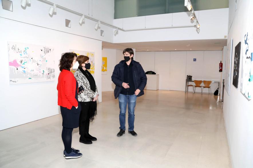 Inauguración Exposición Víctor Barrio "Paisajes Borrados" - Imagen del autor  junto a una obra, charlando con las autoridades municipales. 