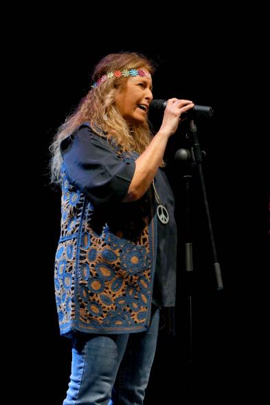   Carnaval de Mayores 2022 - Imagen de la presentadora disfrazada de hippie.