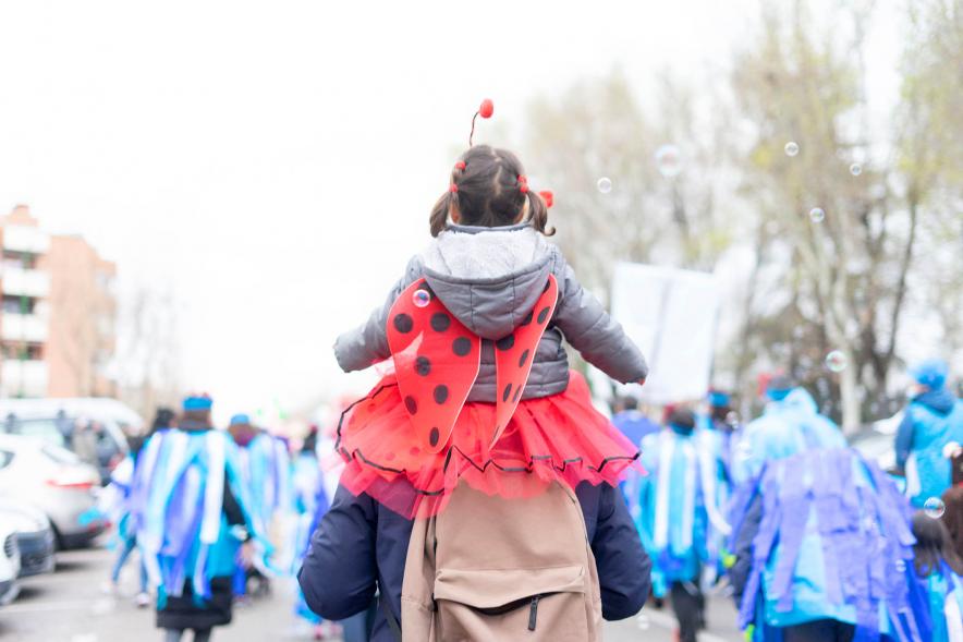 Desfile de Carnaval 2022 - Imagen posterior de una niña a hombros de su padre.