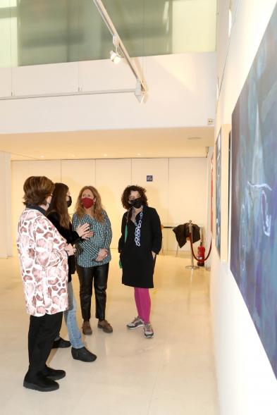 Inauguración Exposición de Pintura de Celia Muñoz - Imagen de la pintora de Celia Muñoz explicando su obra a las autoridades asistentes.