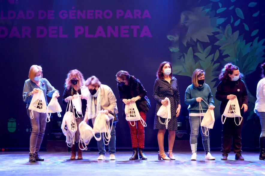 Actos Día de la Mujer en la Esfera - Un grupo de mujeres reciben una bolsa de recuerdo en el escenario.