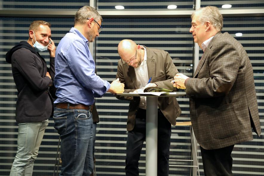 Presentación del Libro de David Galván "Bailando con Lobos hacia la Luz" -  Imagen del autor firmando un libro.
