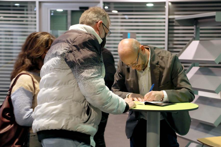   Presentación del Libro de David Galván "Bailando con Lobos hacia la Luz" -  Primer plano del autor firmando libros.
