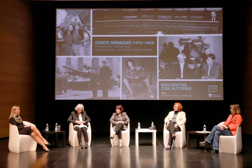  Coloquio y Visita Guiada a la Exposición "Cinco Miradas" - Imagen vista panorámica del escenario donde vemos a las participantes en el coloquio.
