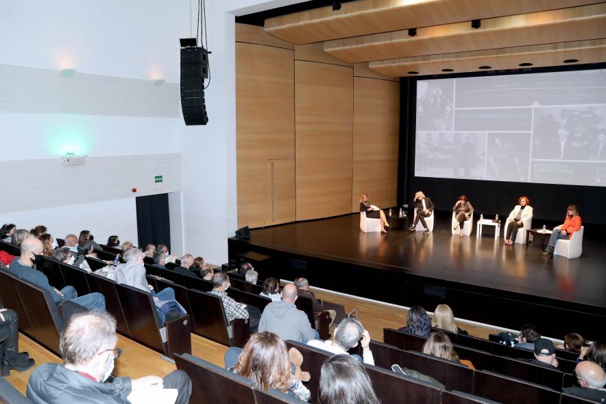 Coloquio y Visita Guiada a la Exposición "Cinco Miradas" - Imagen panorámica del auditorio Paco de Lucía donde se celebra el coloquio, donde vemos al público asistente y el escenario con las fotoperiodistas.
