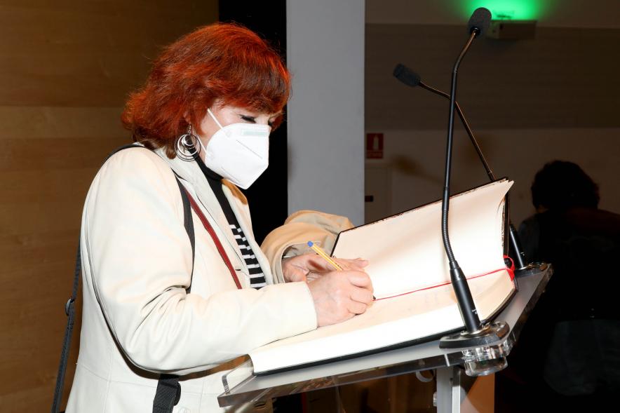 Coloquio y Visita Guiada a la Exposición "Cinco Miradas" - Imagen de un momento de la firma en el libro de honor de la fotoperiodista Mariví Ibarrola.