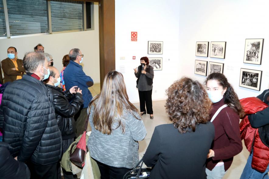 Coloquio y Visita Guiada a la Exposición "Cinco Miradas" - Imagen de Pilar Aymerich realizando la visita guiada de su obra incluida en la exposición “Mujeres Reporteras: Cinco Miradas” y parte del público asistente.
