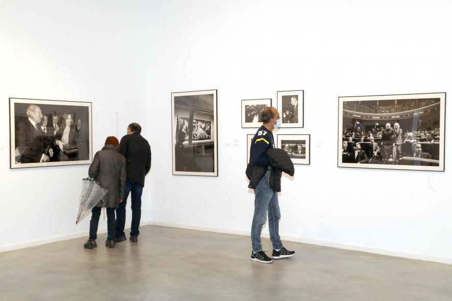   Coloquio y Visita Guiada a la Exposición "Cinco Miradas" - Imagen del público asistente admirando las fotografías.