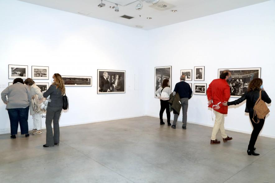Coloquio y Visita Guiada a la Exposición "Cinco Miradas" - Imagen del público asistente admirando las fotografías.
