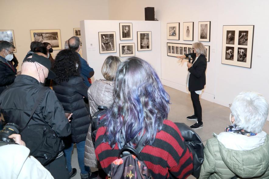 Coloquio y Visita Guiada a la Exposición "Cinco Miradas" - Imagen de Ana Torralva realizando la visita guiada de su obra incluida en la exposición “Mujeres Reporteras: Cinco Miradas” y parte del público asistente.
