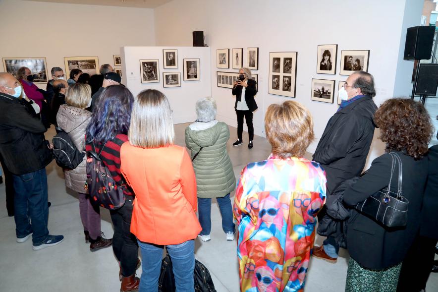Coloquio y Visita Guiada a la Exposición "Cinco Miradas" - Imagen de Ana Torralva realizando la visita guiada de su obra incluida en la exposición “Mujeres Reporteras: Cinco Miradas” y parte del público asistente.