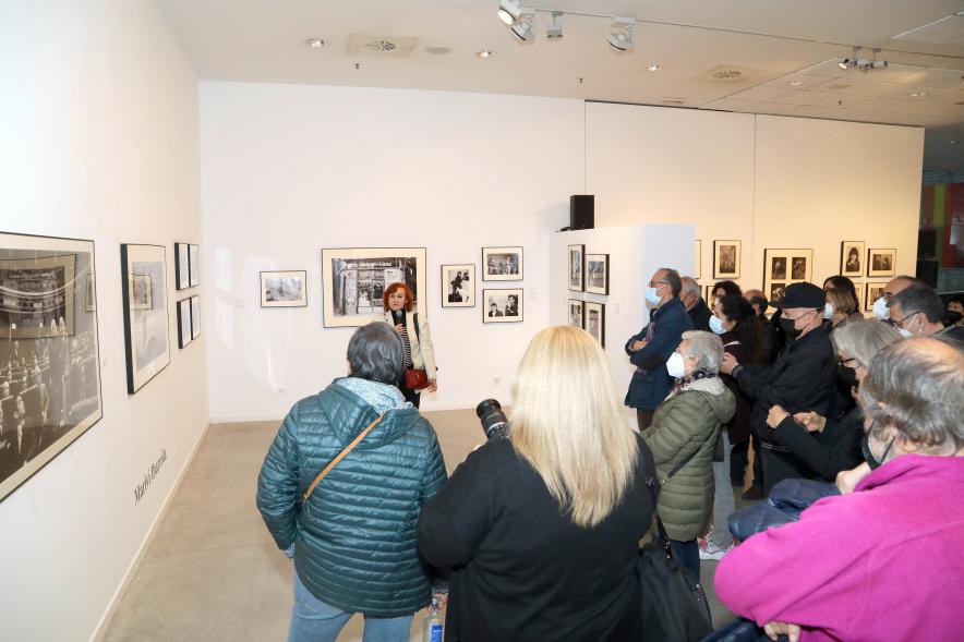 Coloquio y Visita Guiada a la Exposición "Cinco Miradas" - Imagen lejana de Mariví Ibarrola realizando la visita guiada de su obra incluida en la exposición “Mujeres Reporteras: Cinco Miradas” y parte del público asistente.