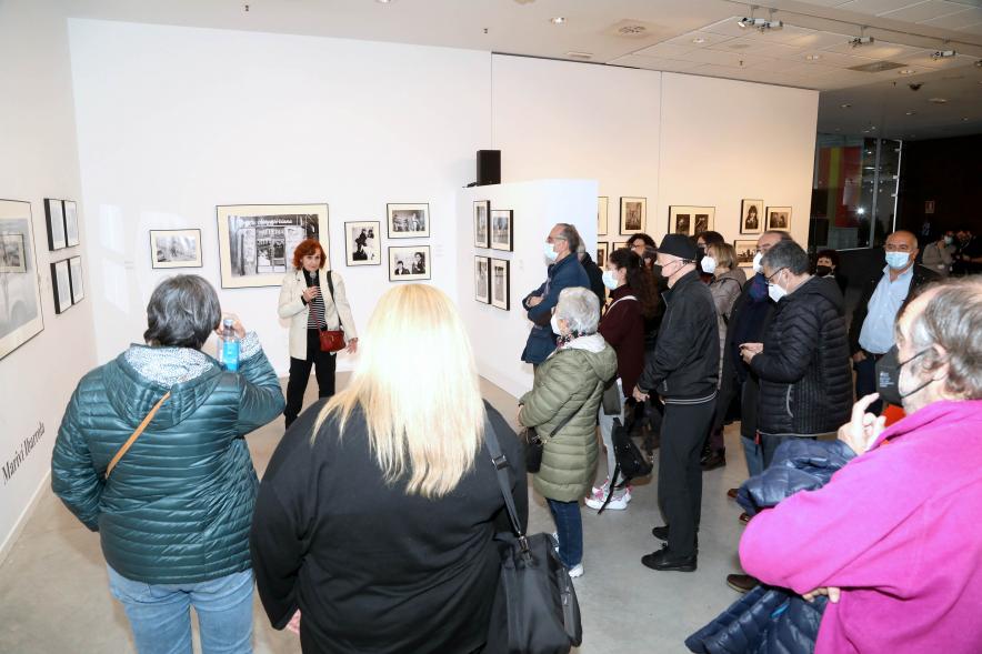 Coloquio y Visita Guiada a la Exposición "Cinco Miradas" - Imagen de Mariví Ibarrola realizando la visita guiada de su obra incluida en la exposición “Mujeres Reporteras: Cinco Miradas” y parte del público asistente.