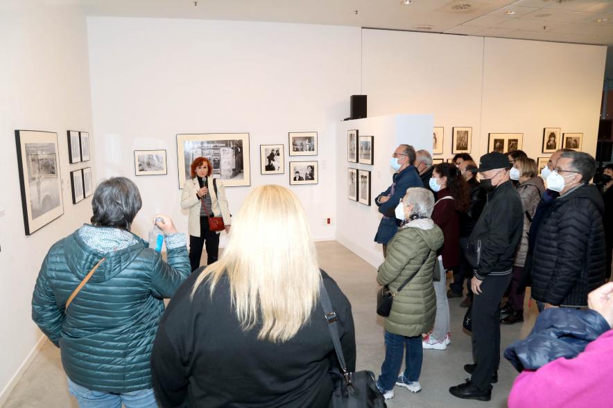 Coloquio y Visita Guiada a la Exposición "Cinco Miradas" - Imagen de Mariví Ibarrola realizando la visita guiada de su obra incluida en la exposición “Mujeres Reporteras: Cinco Miradas” y parte del público asistente.