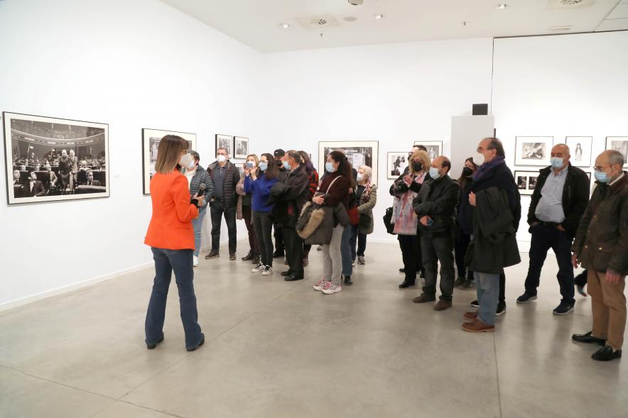 Coloquio y Visita Guiada a la Exposición "Cinco Miradas" - Imagen de Marisa Flórez realizando la visita guiada de su obra incluida en la exposición “Mujeres Reporteras: Cinco Miradas” y parte del público asistente.
