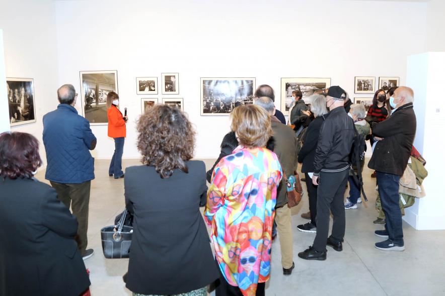 Coloquio y Visita Guiada a la Exposición "Cinco Miradas" - Imagen de Marisa Flórez realizando la visita guiada de su obra incluida en la exposición “Mujeres Reporteras: Cinco Miradas” y parte del público asistente.