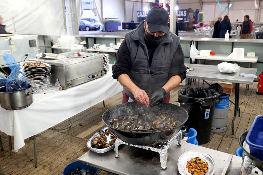 Inauguración XXV Feria del Marisco - Primer plano de un cocinero preparando mejillones.