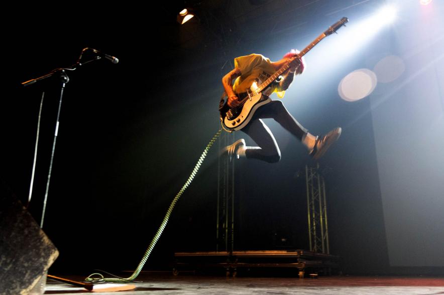 Festival de Música Joven en La Esfera -  Primer plano del salto del guitarra de un grupo musical.