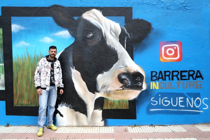   Visita al Mural del Parque Asturias y Cantabria - Imagen del artista David Barrera posando delante  del grafiti que ha pintado en el muro del Parque de Asturias-Cantabria.