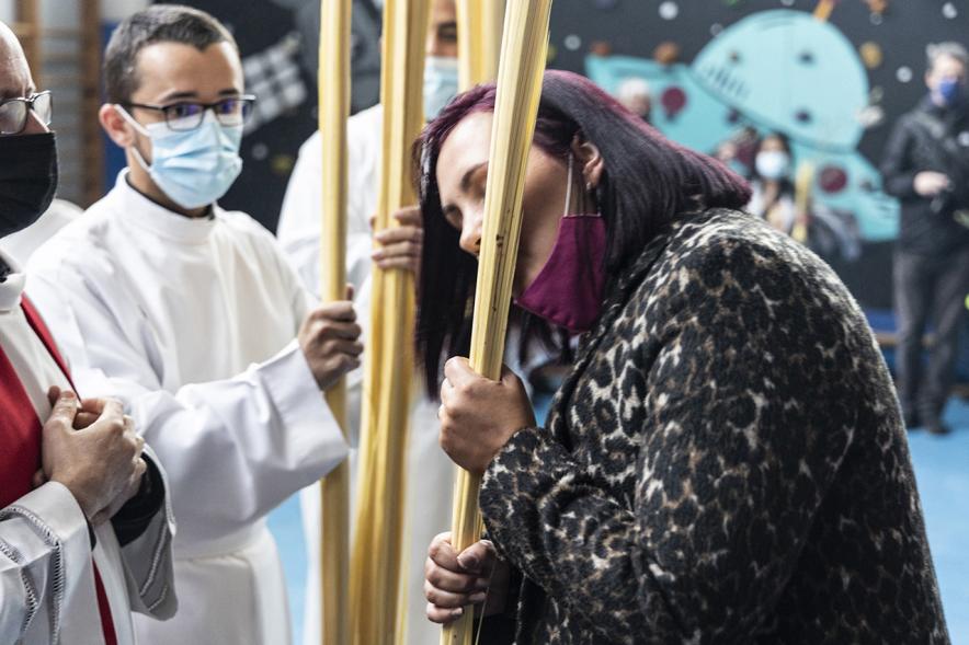 Semana Santa 2022 - Domingo de Ramos -  Imagen de una señora besando la palma.