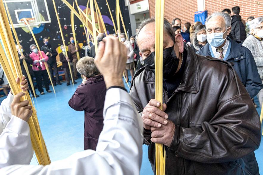 Semana Santa 2022 - Domingo de Ramos -  El sacerdote bendice una a un las palmas.
