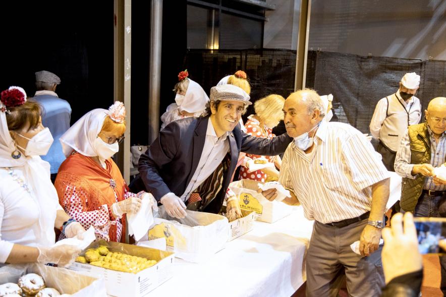 Fiesta del Dos de Mayo en La Esfera - Imagen del alcalde Aitor Retolaza fotografiándose con una persona durante el reparto de rosquillas listas y tontas.