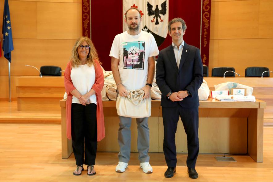  3a Entrega Canastillas Mis Primeros Pasos en Alcobendas - 2022 - Imagen del alcalde Aitor Retolaza y la concejala de Familia Inmaculada Puyalto posando con  una persona que acaba de recibir una canastilla.