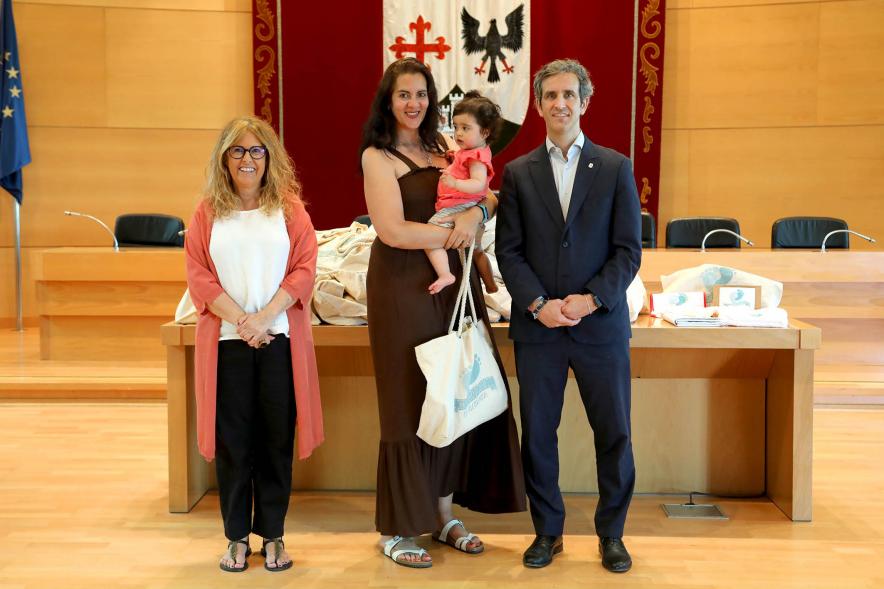  3a Entrega Canastillas Mis Primeros Pasos en Alcobendas - 2022 - Imagen del alcalde Aitor Retolaza y la concejala de Familia Inmaculada Puyalto posando con  una persona que acaba de recibir una canastilla.