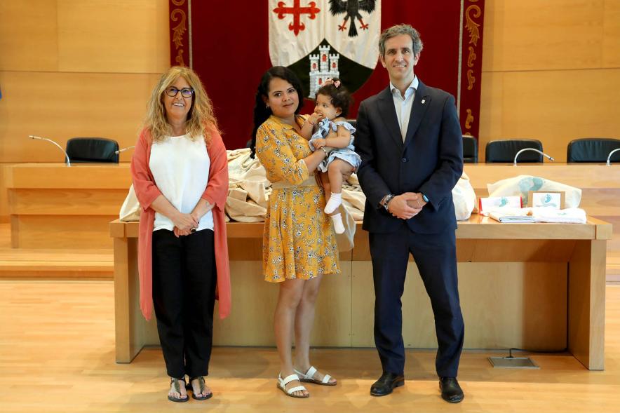  3a Entrega Canastillas Mis Primeros Pasos en Alcobendas - 2022 - Imagen del alcalde Aitor Retolaza y la concejala de Familia Inmaculada Puyalto posando con  una persona que acaba de recibir una canastilla.