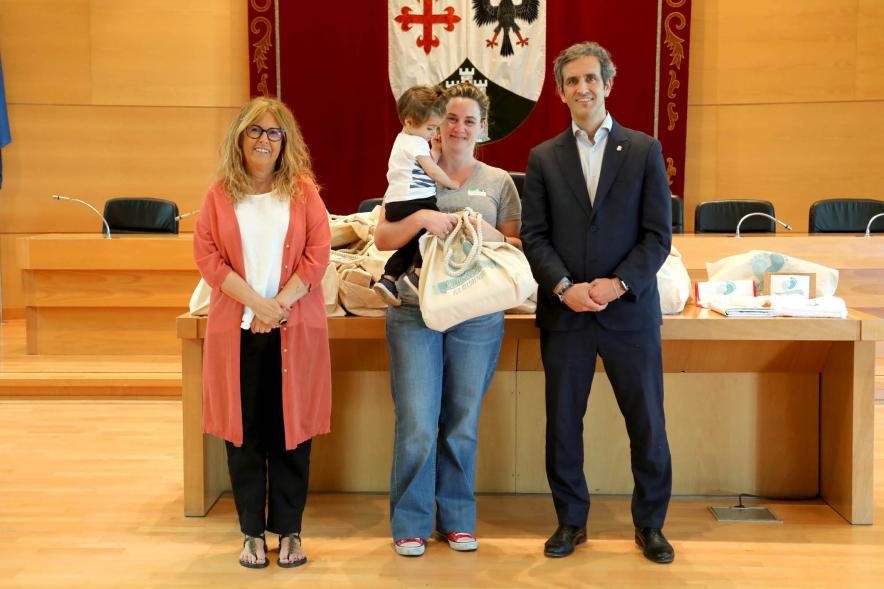 3a Entrega Canastillas Mis Primeros Pasos en Alcobendas - 2022 - Imagen del alcalde Aitor Retolaza y la concejala de Familia Inmaculada Puyalto posando con  una persona que acaba de recibir una canastilla.
