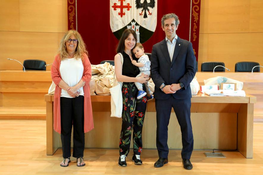 3a Entrega Canastillas Mis Primeros Pasos en Alcobendas - 2022 - Imagen del alcalde Aitor Retolaza y la concejala de Familia Inmaculada Puyalto posando con  una persona que acaba de recibir una canastilla.
