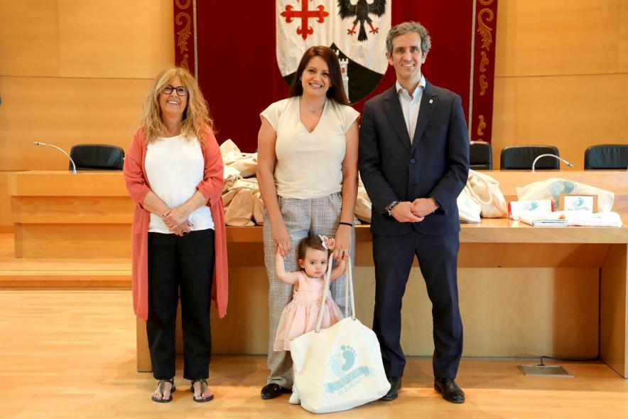 3a Entrega Canastillas Mis Primeros Pasos en Alcobendas - 2022 - Imagen del alcalde Aitor Retolaza y la concejala de Familia Inmaculada Puyalto posando con  una persona que acaba de recibir una canastilla.