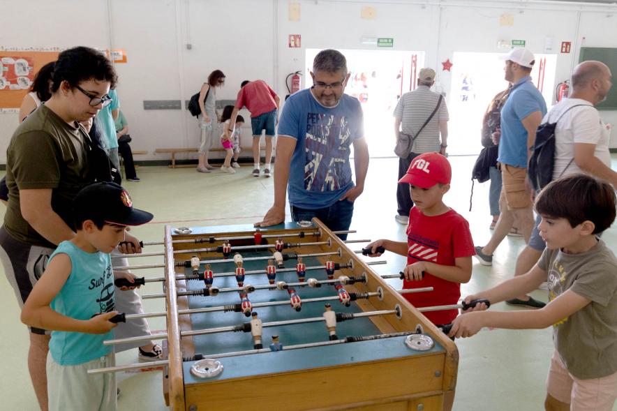 Niños jugando al futbolín ante el alcalde