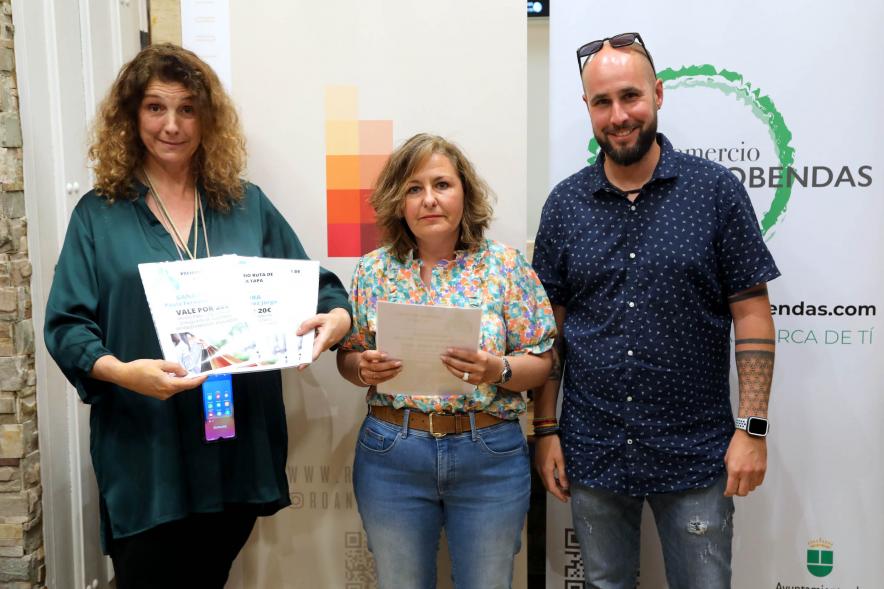 Entrega Premios Ruta de la Tapa 2022 - Imagen de un representante de la Asociación de Comerciantes y Hosteleros La Menina y de AICA haciendo entrega de un premio entre las personas que votaron.