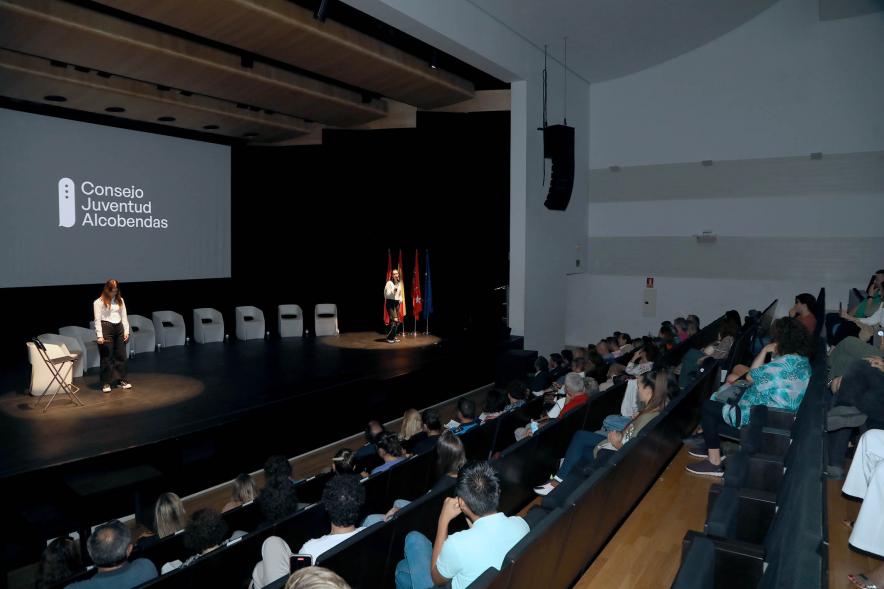 Acto sobre Salud Mental del Consejo de la Juventud de Alcobendas - Plano de dos jóvenes sobre el escenario escenificando  una situación y  del público.