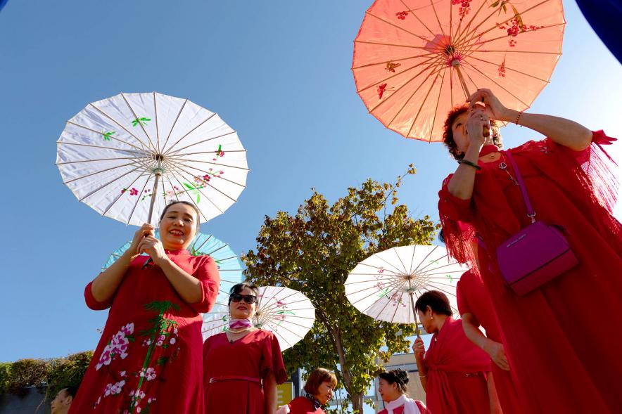 Desfile Festival Intercultural Día de la Hispanidad - Desfile de un grupo oriental con las sombrillas tradicionales.