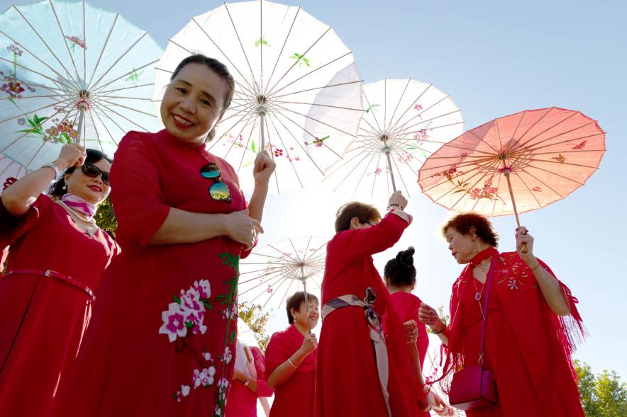 Desfile Festival Intercultural Día de la Hispanidad - Desfile de un grupo oriental con las sombrillas tradicionales.