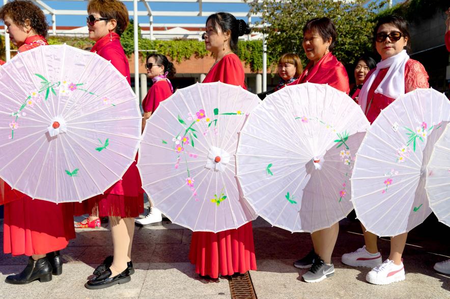   Desfile Festival Intercultural Día de la Hispanidad - Desfile Festival Intercultural Día de la Hispanidad - Desfile de un grupo oriental con las sombrillas tradicionales.