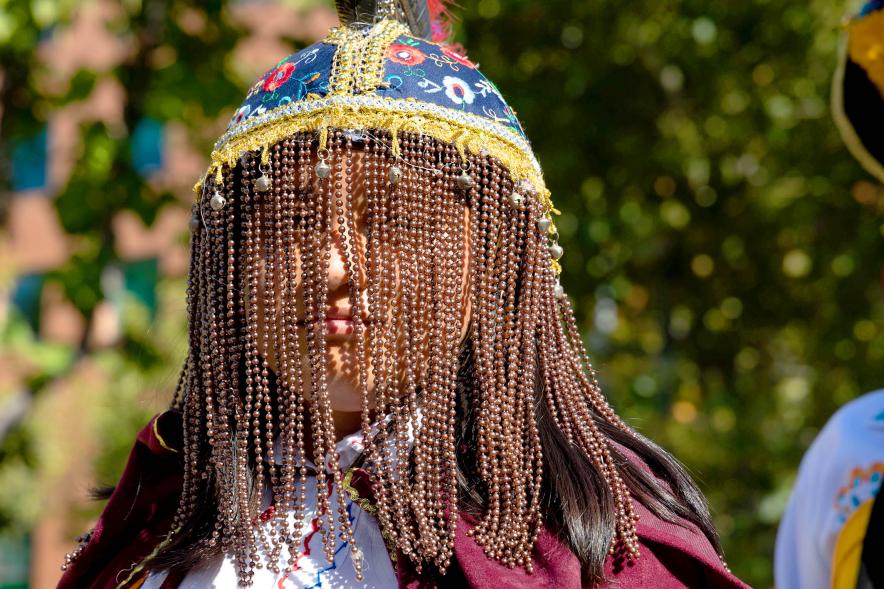 Desfile Festival Intercultural Día de la Hispanidad - Primer plano de una participantes con el cabello  tradicional del país.