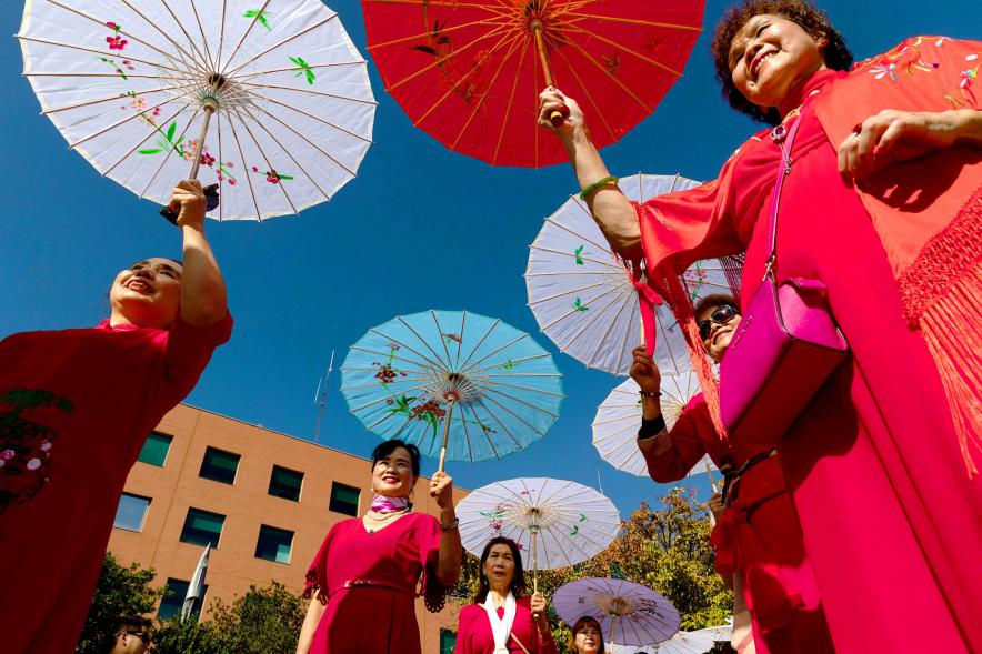 Desfile Festival Intercultural Día de la Hispanidad - Desfile de un grupo oriental con las sombrillas tradicionales.