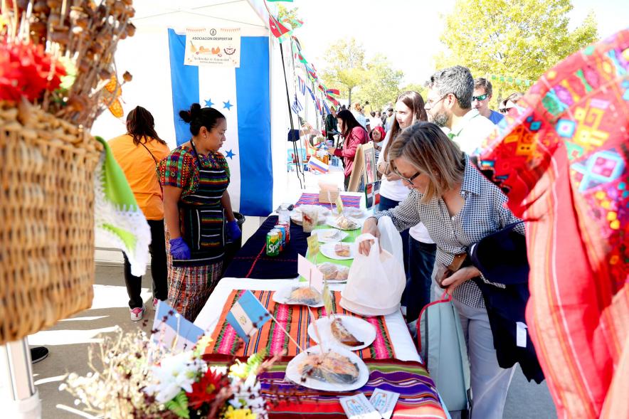Festival Intercultural Mercado Gastronómico y Artesanía Día de la Hispanidad - Primer plano  de un expositor con degustación del producto típico del país.
