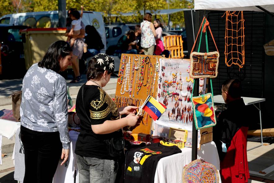 Festival Intercultural Mercado Gastronómico y Artesanía Día de la Hispanidad -  Primer plano de los visitantes contemplado la mercancía ofrecida.