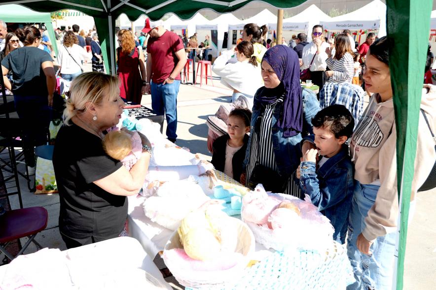 Festival Intercultural Mercado Gastronómico y Artesanía Día de la Hispanidad -  Primer plano de los visitantes contemplado la mercancía ofrecida.