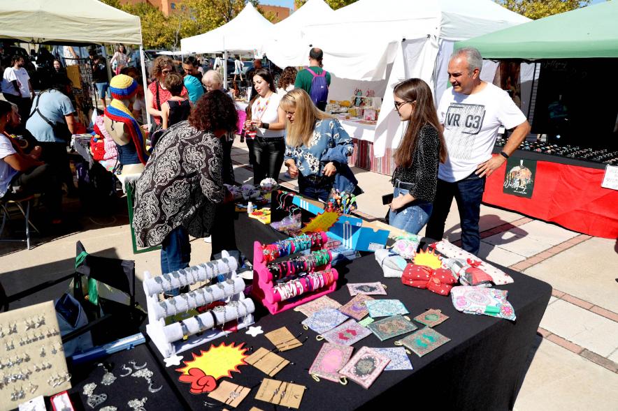 Festival Intercultural Mercado Gastronómico y Artesanía Día de la Hispanidad -  Primer plano de los visitantes contemplado la mercancía ofrecida.