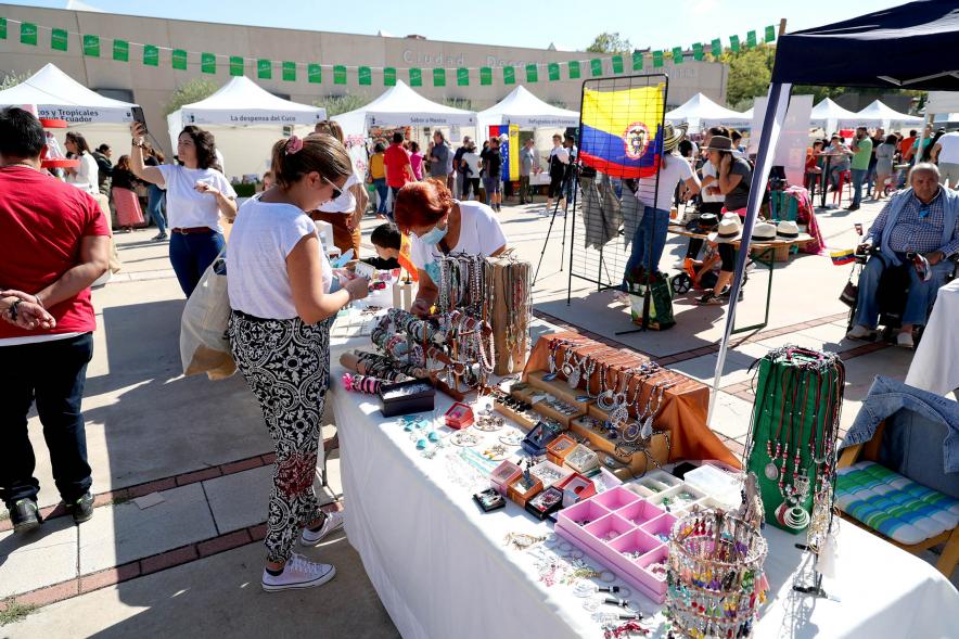 Festival Intercultural Mercado Gastronómico y Artesanía Día de la Hispanidad -  Primer plano de los visitantes contemplado la mercancía ofrecida.