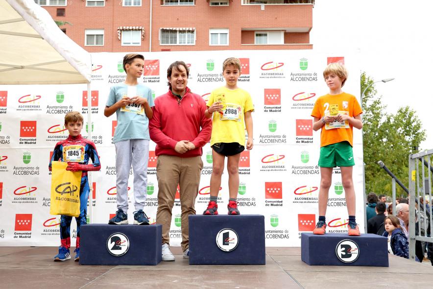 Milla Escolar 2022 -  Alberto Polo, responsable del distrito centro, junto al pódium de los niños ganadores.