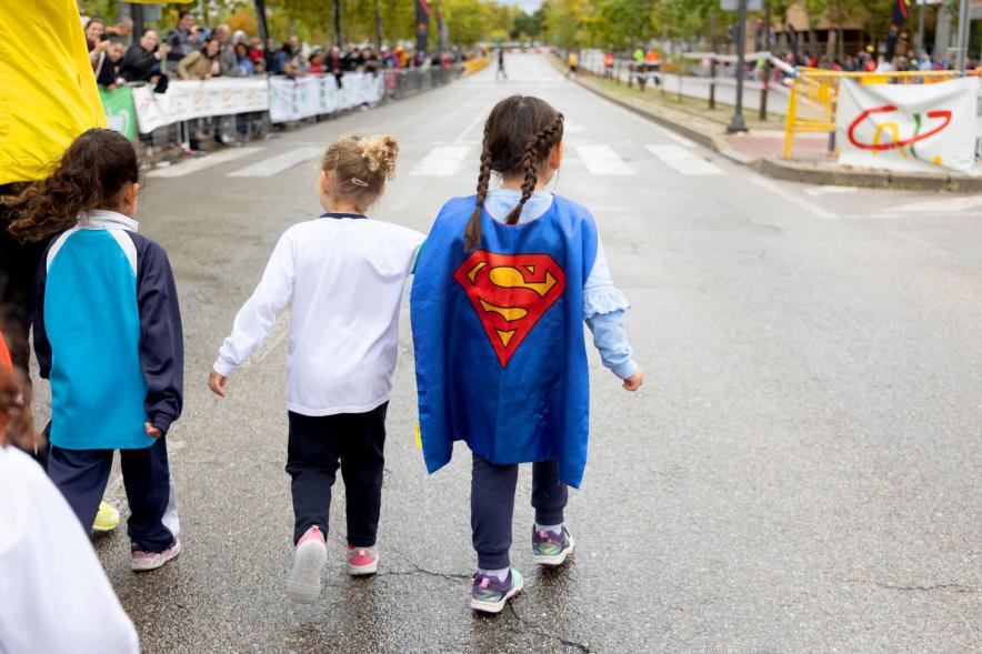 Milla Escolar 2022 - Imagen de tres niños  de la mano.