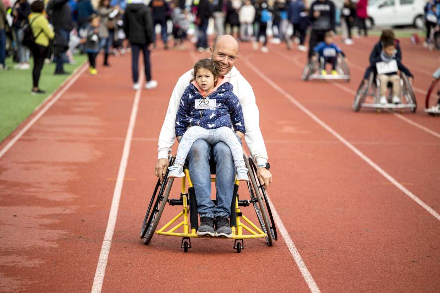 Participante con niña en su regazo durante la carrera