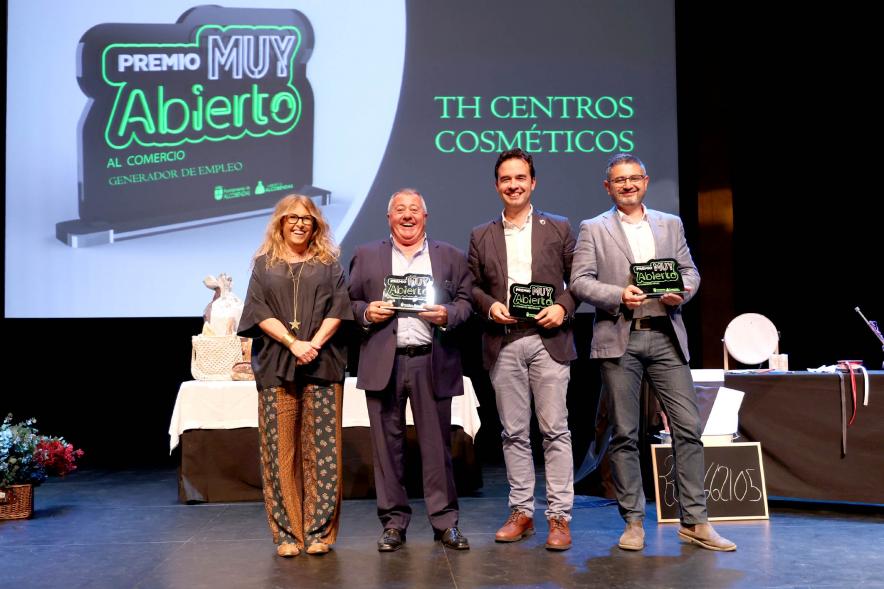 Delegación municipal hace entrega de uno de los premios a un galardonado